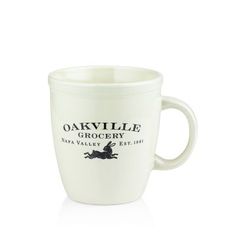 a white coffee cup with the words oakville grocery on it and a black horse