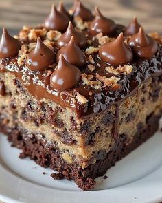 a piece of cake with chocolate frosting and nuts on top sitting on a plate