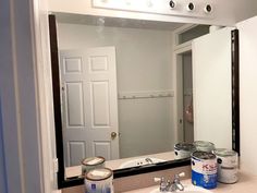 a bathroom mirror that has some paint on the counter and it's reflection in the mirror