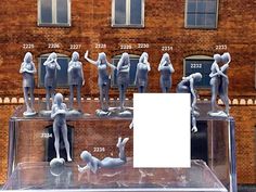 there are many statues on display in front of a brick building that is displaying the size of each individual figure