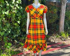 "Just about thee cutest little number you ever did see! Adorable 1970s primary colored plaid midi dress by Petiteen! Lightweight synthetic fabric in a bold primary colored plaid print, bobble button closures from chest to waist, ruffled hem, nylon back zip closure, and the sweetest puffed sleeves! Excellent vintage condition with no noted flaws or defects (zipper's fully functional, just a smidge snug on the mannequin).  Best fits an XS. See measurements for exact fit.  APPROXIMATE FLAT MEASUREMENTS Shoulder: 14\" Sleeve: 8.5\" Chest: 16.5\" Waist: 12.5\" Hip: 21\" Length: 45\"" Retro Plaid Mini Dress, Puff Sleeve Dress, Check Dress, 50s Dresses, Puffed Sleeves Dress, Puffed Sleeves, Plaid Print, Dress Suits, Printed Maxi