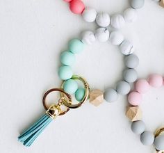 These silicone bead bangle keychains / wristlets are perfect for the girl who's always got her hands full! Elastic key ring bangle with small-sized tassels High quality silicone beads in vibrant colors Available colors: Hot Pink, Aqua Blue / Turquoise, Leopard / Black, Green Camo, Candy, Sunny Yellow Measures 3" inside bracelet (Elastic), 4" outside bracelet, 2" tassel Total length: 9" Silicone Bead Wristlet, Bracelet Keychains, Black Candy, Leopard Black, Cherry Candy, Tassel Bracelet, Bead Bangles, Aqua Turquoise, Sunny Yellow