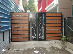 an iron gate with wooden slats and flowers on it