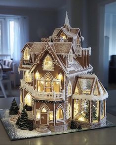 a lighted gingerbread house with snow on the roof