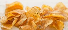 a pile of potato chips sitting on top of a wooden table