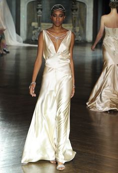 a model walks down the runway in a gold gown