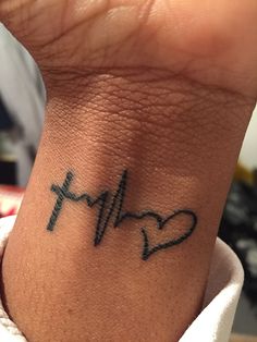 a heart and heartbeat tattoo on the wrist