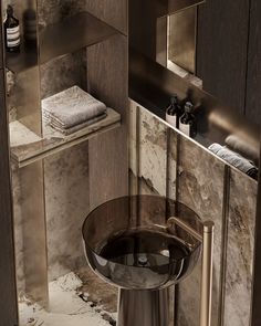 a bathroom with marble walls and flooring, including a round sink in the corner