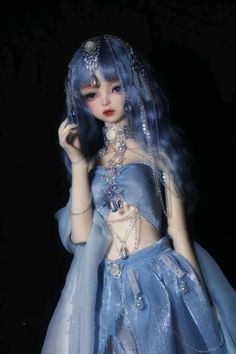 a doll with blue hair wearing a dress