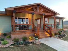 a small house with wooden porchs and steps leading up to the front door area