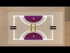 a room with white walls and purple circles on the ceiling is lit by recessed lights