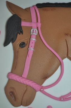 a cake shaped like a horse with pink bridle on it's head