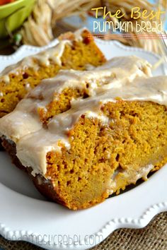 the best pumpkin bread with icing is on a white plate next to some fruit