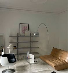 a living room filled with furniture and a glass coffee table in front of a book shelf