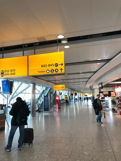 people are walking through an airport with their luggage