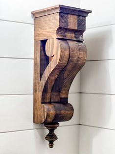 a wooden clock mounted to the side of a wall