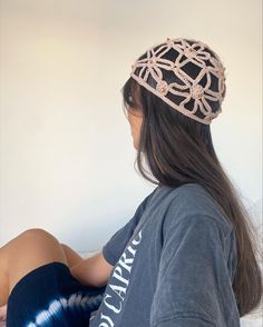 a young woman sitting on top of a bed wearing a headband made out of chains