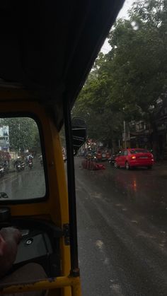 a view from the back seat of a vehicle on a city street with cars driving down it