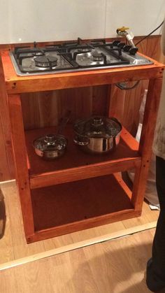 a stove top oven sitting on top of a wooden shelf