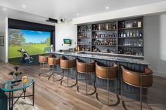 a bar with several stools in front of it and a television on the wall