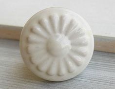 a white door knob sitting on top of a wooden floor next to a window sill