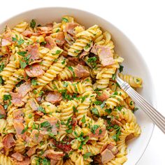 a white bowl filled with pasta and ham