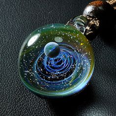 "After purchase, send the phone number to me because the post office needs it so that it can be reached faster Its materials: opal, glass, gold and silver Glass pendant measures approximately 0.86-0.95\" (2.2-2.4 cm) in diameter. 1.2\"(3 cm) in height The glass pendant comes with a brown cord . (Adjustable the length of black cord via he wooden bead.) This charming necklace will arrive at your home securely nestled come in a lighting gift box and tucked in a safe package :) If your purchase is a Space-themed Pendant Necklace As Gift, Universe Necklace, Galaxy Necklace, Galaxy Pendant, Lighting Gifts, Unique Birthday Gift, Small Gift Bags, Glass Artwork, Silver Glass