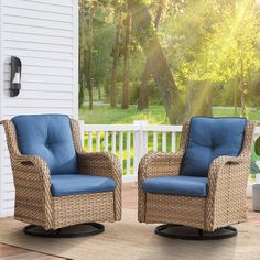 two wicker chairs sitting on top of a wooden deck