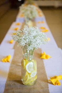 a vase filled with lemon slices and baby's breath on top of a table