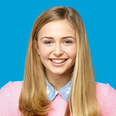 a woman with long blonde hair wearing a pink shirt and blue polka dot collar smiling at the camera