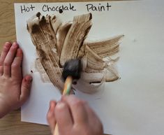 a person is painting a piece of paper with chocolate paint