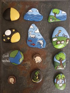 some rocks with different designs on them sitting on a table next to other rocks and magnets