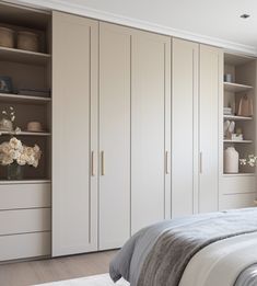 a large white bed sitting in a bedroom next to a tall bookcase filled with books