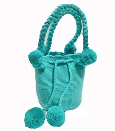 a small blue purse with pom poms on it