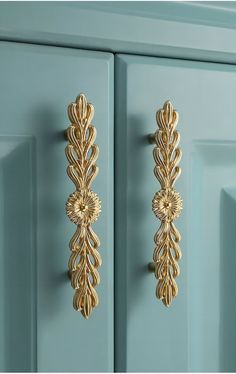 an ornate gold door handle on a blue cabinet