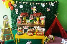 a birthday party with mickey mouse decorations and desserts on the table in front of a green wall