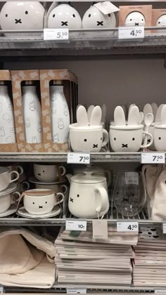 the shelves are filled with dishes and mugs that have bunny ears drawn on them