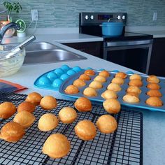 some muffins are cooling on a rack in the middle of a kitchen counter