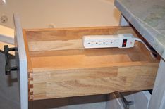 a wooden drawer with an electronic device on it