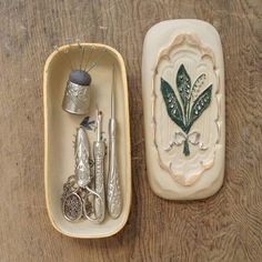 two small trays with sewing tools in them