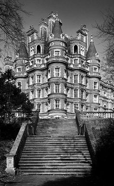 an old building with many windows and steps leading up to the top floor is shown in black and white