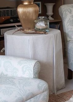 a living room filled with furniture and a lamp on top of a table next to a chair