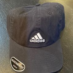 This Cap Comes New, With The Tags Still Intact, And Has Never Been Worn Before. This Is A Men’s Adidas Adjustable Fit Cap And The Body Is 100% Cotton. This Is Mostly Black With The White Adidas Lettering And Symbol On The Front And Back Of The Cap. This Hat Sells In Stores For A Retail Price Of $24. Adidas Casual Hat For Sports Events, Casual Adidas Hat For Sports Events, Adidas Cotton Snapback Baseball Cap, Adidas Sports Cap, Adidas Cap For Sports Events, Adjustable Adidas Cotton Hat, Adidas Sports Event Hats, Casual Adidas Baseball Cap For Sports Events, Classic Black Dad Hat For Sports