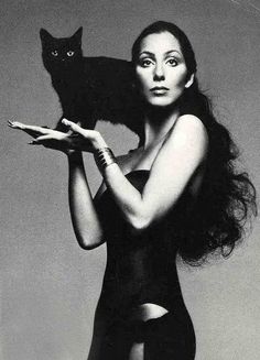 a woman holding a black cat in her arms and the caption reads instagram