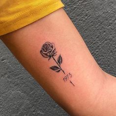 a small rose tattoo on the arm