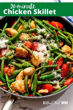 a skillet filled with chicken, green beans and tomatoes