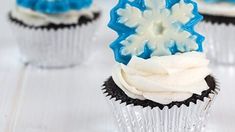 cupcakes decorated with frosting and blue icing are sitting on a table