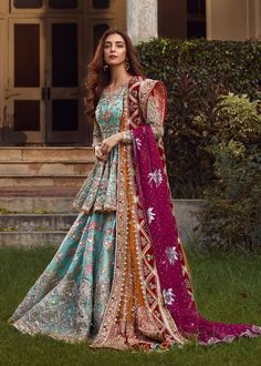 a woman in a long dress standing on the grass