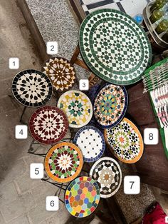 many different colored plates on a table with numbers in front of them and the names below it