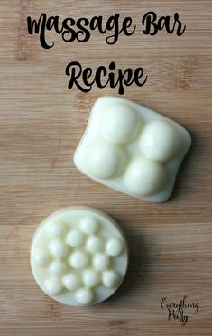 two pieces of white soap sitting on top of a wooden table next to each other